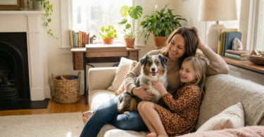 a woman and daughter sitting on a couch hugging their dog